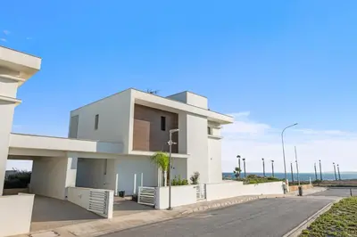 a white house with a road in front of it at Serenity Waves Villa 1 in Sophtadhes
