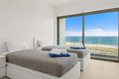 two beds in a bedroom with a view of the beach at Serenity Waves Villa 1 in Sophtadhes