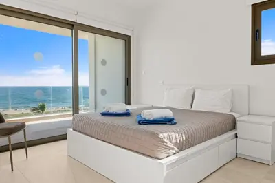 a bedroom with a bed with a view of the ocean at Serenity Waves Villa 1 in Sophtadhes