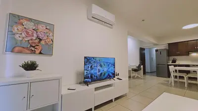 a living room with a flat screen tv on a cabinet at STAY Skyline Nest in Larnaka