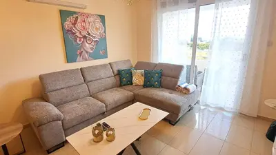 a living room with a couch and a table at NISSI BEACH Apt 2 RESORT AND SEA VIEW FREE WIFI in Ayia Napa