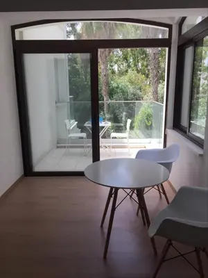 a table and chairs in a room with a large window at Modern 1 bedroom sea view beach apartment in Limassol