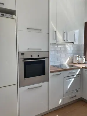 a kitchen with white appliances and white cabinets at Modern 1 bedroom sea view beach apartment in Limassol