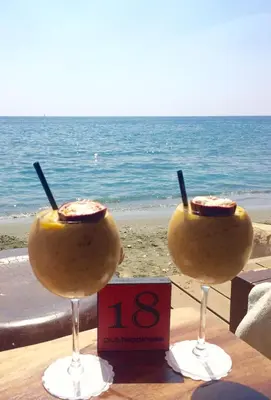 two wine glasses sitting on a table near the ocean at Modern 1 bedroom sea view beach apartment in Limassol