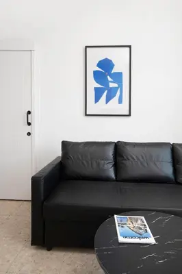 a black leather couch in a living room with a table at Urban Condo 11 - 1 Bdr in Nicosia