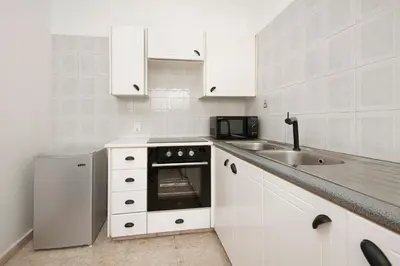 a white kitchen with a sink and a stove at Urban Condo 11 - 1 Bdr in Nicosia