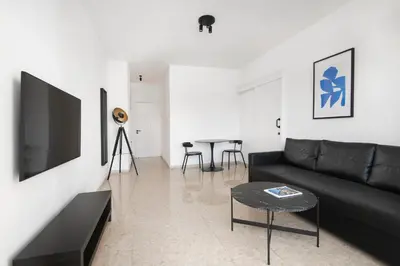 a living room with a black couch and a table at Urban Condo 11 - 1 Bdr in Nicosia