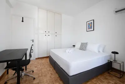 a white bedroom with a bed and a desk at Urban Condo 11 - 1 Bdr in Nicosia