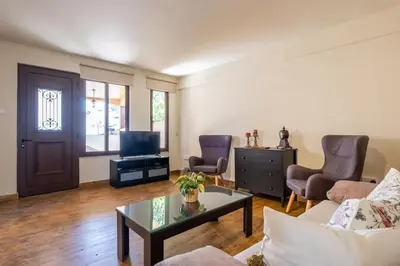 a living room with a couch and a table and a tv at Traditional House Agia Varvara Village in Ayvaryara