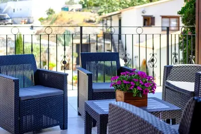 a patio with chairs and a table with flowers on it at Traditional House Agia Varvara Village in Ayvaryara