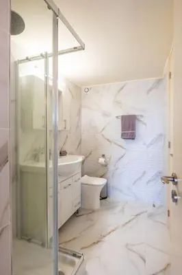 a bathroom with a shower and a toilet and a sink at Traditional House Agia Varvara Village in Ayvaryara
