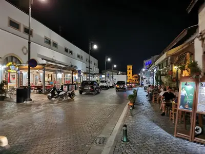 a city street at night with cars driving down the street at Must Stay - Finikoudes Studio in Larnaka