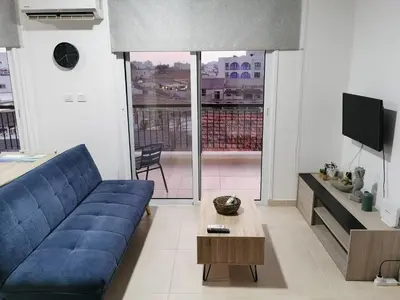 a living room with a blue couch and a tv at Must Stay - Finikoudes Studio in Larnaka