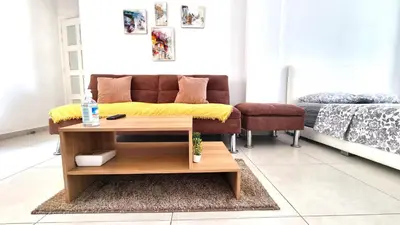 a living room with a couch and a coffee table at Stylish Studio - 2 Minutes from Kastella Beach in Larnaka