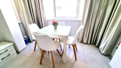 a white table and chairs in a room with a window at Stylish Studio - 2 Minutes from Kastella Beach in Larnaka