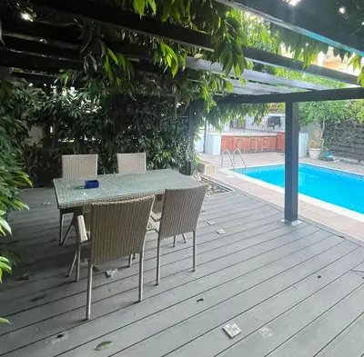 a table and chairs on a deck next to a swimming pool at A Detached Floor in Parekklisha