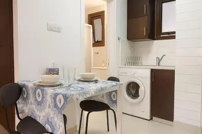 a kitchen with a table with chairs and a washing machine at Old town studio in Limassol