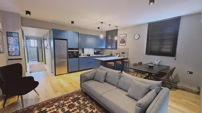 a living room with a couch and a table and a kitchen at STAY Lima Soul Apartment in Limassol
