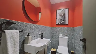an orange bathroom with a sink and a mirror at STAY Lima Soul Apartment in Limassol