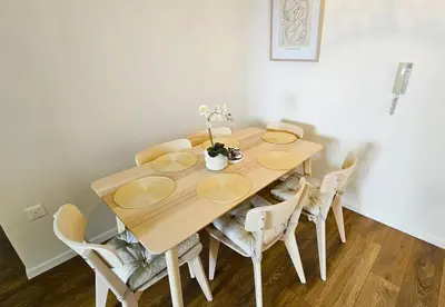 a wooden table with chairs and a vase of flowers on it at Molos Beachfront City-Centre in Limassol