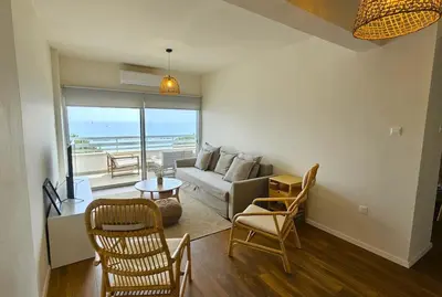a living room with a couch and a table and chairs at Molos Beachfront City-Centre in Limassol