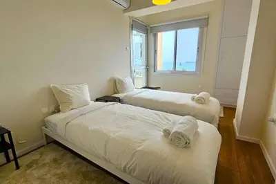 two beds in a room with a window at Molos Beachfront City-Centre in Limassol
