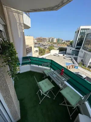 a balcony with chairs and tables on a building at Nikoletta apartman in Limassol