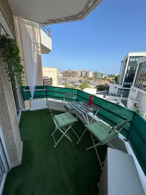 a balcony with two chairs and a green roof at Nikoletta apartman in Limassol