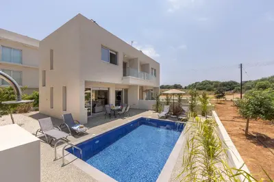 a villa with a swimming pool in front of a house at Protaras Mythical Seas in Protaras