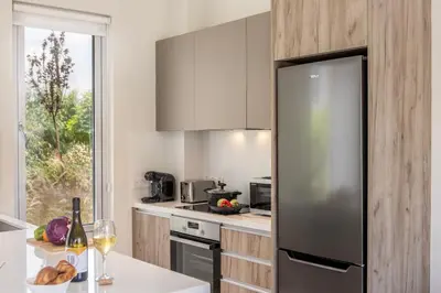 a kitchen with a stainless steel refrigerator and a window at Protaras Mythical Seas in Protaras