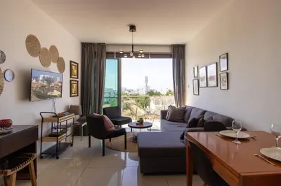 a living room with a couch and a table at Seafront Stylish Apt, Protaras in Protaras