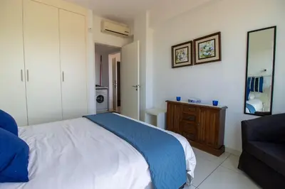 a bedroom with a white bed and a couch at Seafront Stylish Apt, Protaras in Protaras