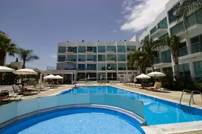 a large swimming pool in front of a hotel at Seafront Stylish Apt, Protaras in Protaras