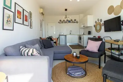 a living room with a couch and a table at Seafront Stylish Apt, Protaras in Protaras