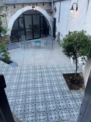 a patio with a table and chairs and a tree at Calavato Cottage in Kalavasos