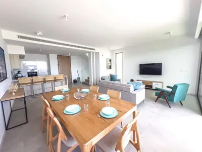 a dining room and living room with a table and chairs at Azure Breeze Villa - Roof Garden & Sea Views in Protaras