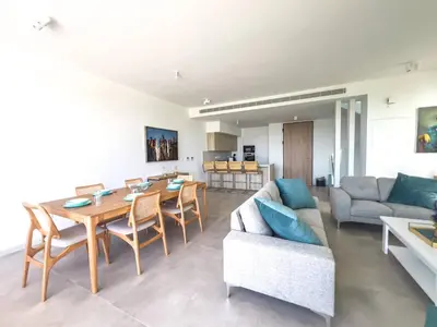a living room with a table and a couch at Azure Breeze Villa - Roof Garden & Sea Views in Protaras