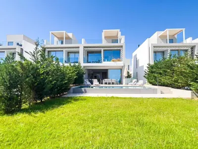 a large white house with a lawn in front of it at Azure Breeze Villa - Roof Garden & Sea Views in Protaras