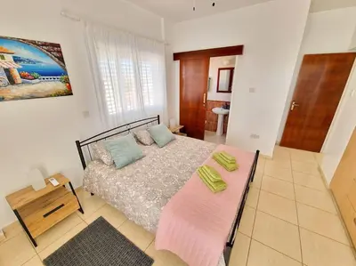 a bedroom with a bed with a pink blanket at Villa Malama in Paralimni