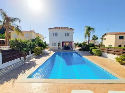 a swimming pool in front of a house at Villa Malama in Paralimni