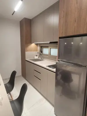 a kitchen with a stainless steel refrigerator and black chairs at IOLENA Seaview Apartment in Pyla