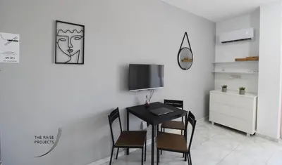 a dining room with a black table and chairs at Raise Limassol Coastal City Break in Limassol