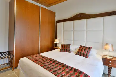 a bedroom with a large bed with a wooden headboard at Vasilikis House in Kalopanayiotis