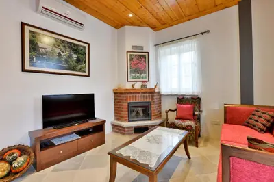 a living room with a tv and a fireplace at Vasilikis House in Kalopanayiotis