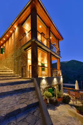 a large wooden house with stairs and a balcony at Vasilikis House in Kalopanayiotis