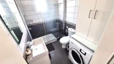 a small bathroom with a toilet and a shower at Beachside Comfort - 2Br Apt,5 Min to the Beach in Larnaka
