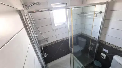 a shower with a glass door in a bathroom at Beachside Comfort - 2Br Apt,5 Min to the Beach in Larnaka