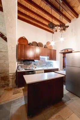 a large kitchen with wooden cabinets and a refrigerator at Villa To Palati with Private Pool Anogyra in Anoyira