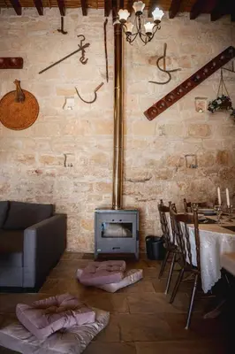 a living room with a fireplace and a table and chairs at Villa To Palati with Private Pool Anogyra in Anoyira