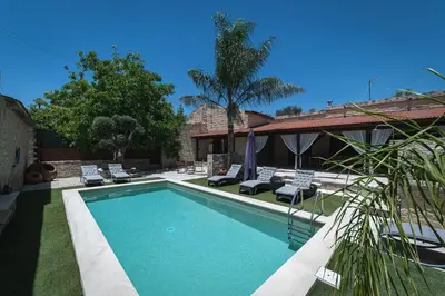 a swimming pool with lounge chairs and a house at Villa To Palati with Private Pool Anogyra in Anoyira